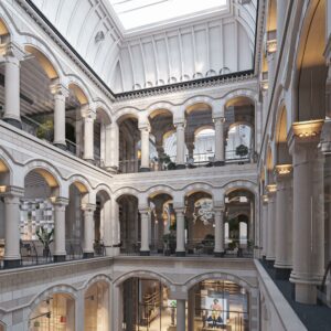 Een lichtovergoten, monumentale binnenruimte met meerdere verdiepingen en klassieke bogen aan de Nieuwezijds Voorburgwal.